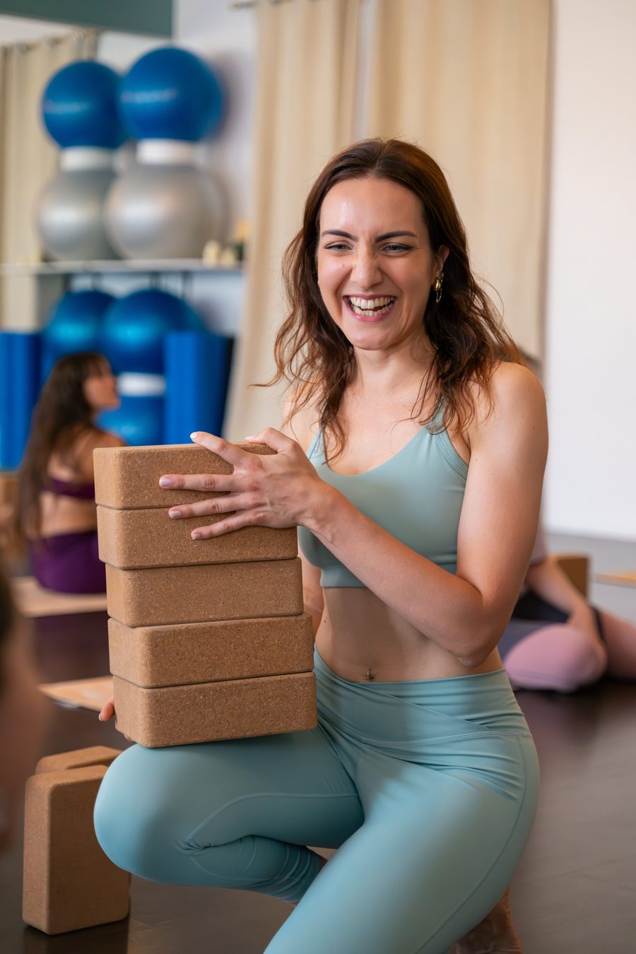 Camille, professeure de yoga, souriante en studio